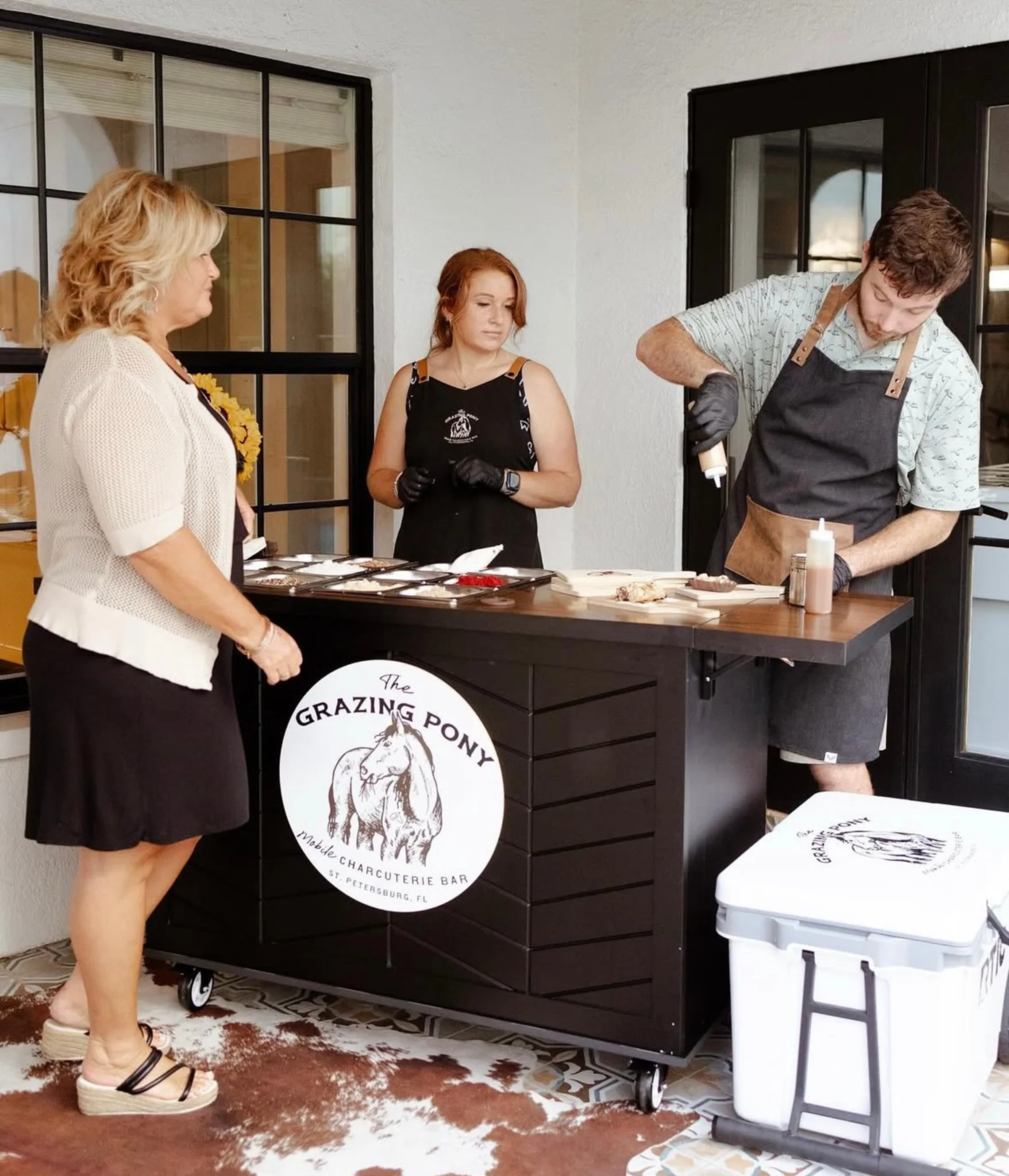 Charcuterie grazing bar catering with staff preparing fresh boards for an event