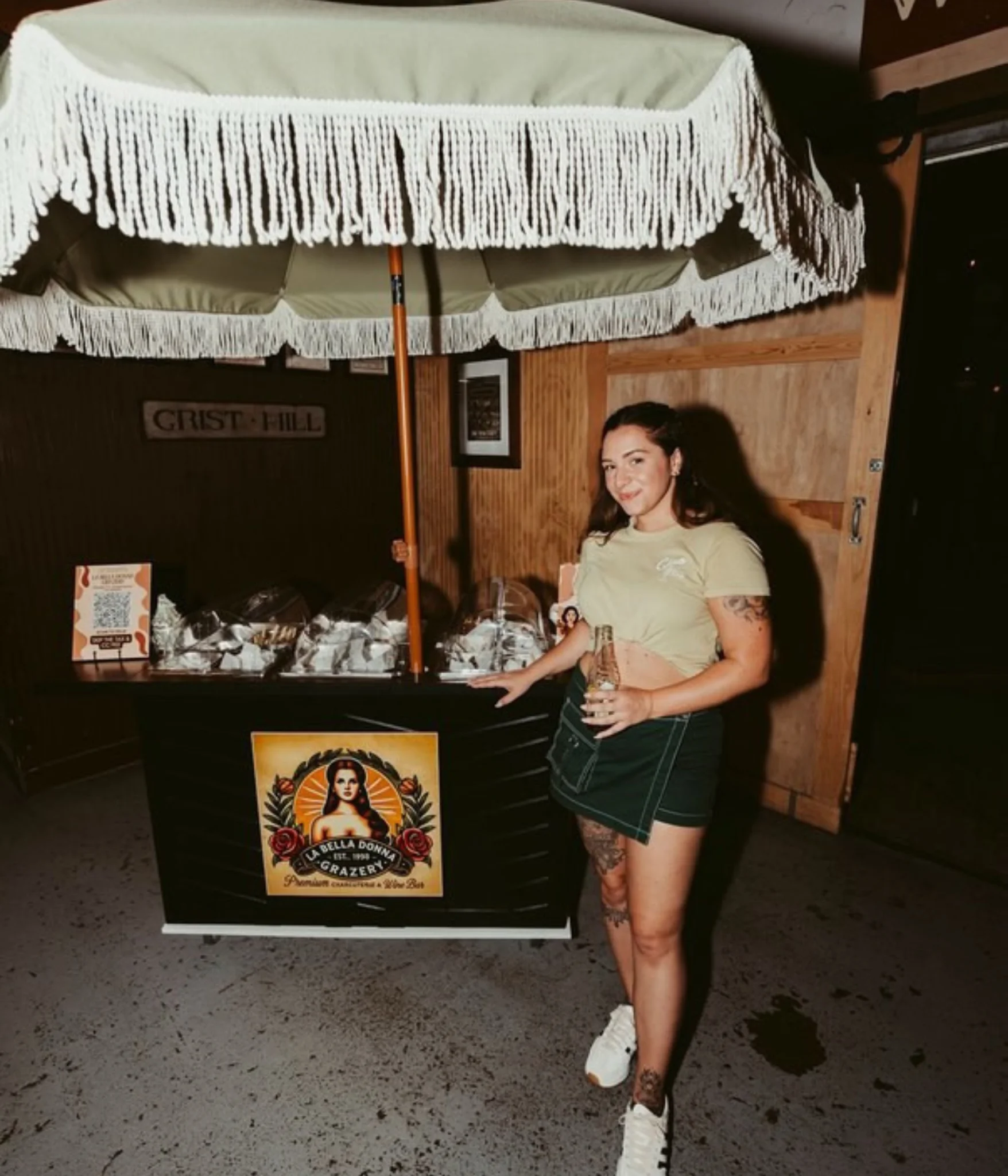 Mobile charcuterie cart with umbrella display at a private indoor venue